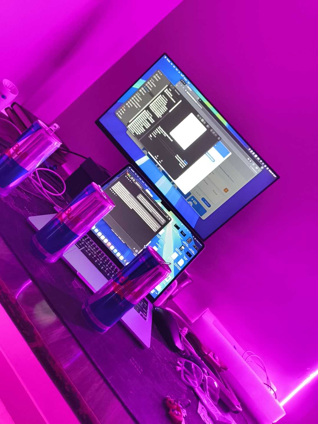 Late night desk setup with dual monitors and neon lighting