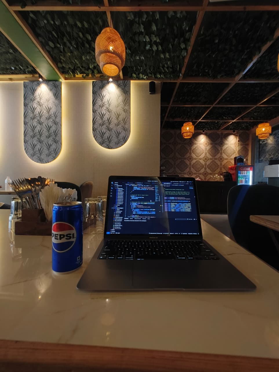 MacBook with code open at ambient cafe